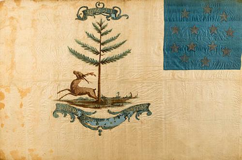 <p>A flag painted on yellowing white silk, somew帽子。 worn. In the upper lefthand corner is a square of blue silk with 13 stars arranged in a circle. In the center is a bounding stag beneath a pine tree. A large cartouche underneath, slightly peeling, reads “The Bucks of America,” smaller cartouche at the top of the image has the initials “J-G-W-H.” painted in gold.</p>
